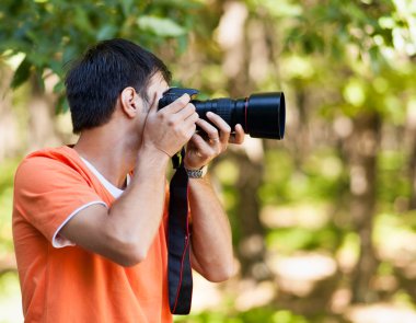 genç adam ormanda fotoğraf çekmek