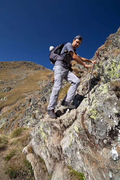 Man hiking on difficult mountain trail — Stock Photo, Image