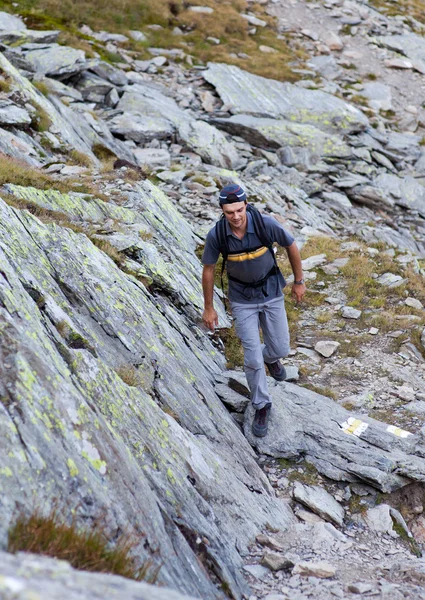 Junger Mann wandert auf Bergpfad — Stockfoto