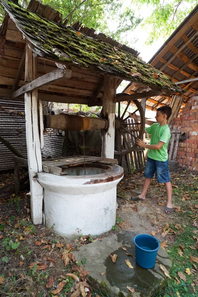Écolier obtenir de l'eau de puits — Photo