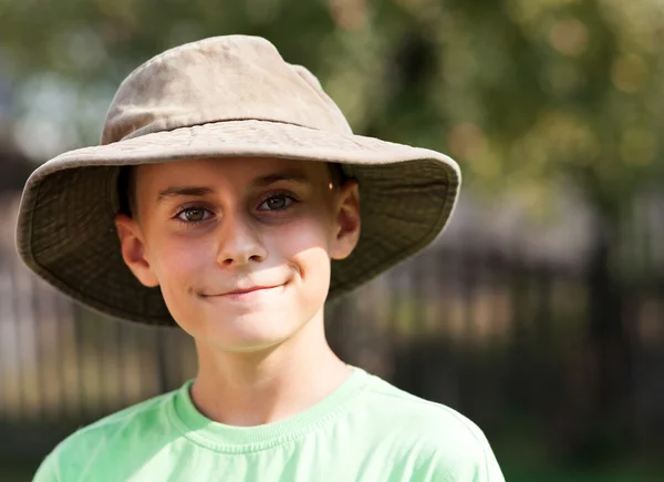 Closeup portrait of a schoolboy with big hat at countryside — Stock Photo, Image