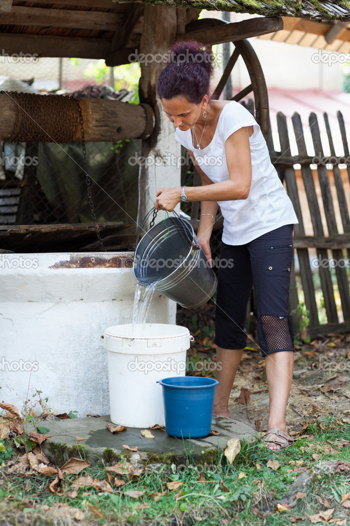 Woman getting water from well