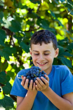 elle üzüm dolu mutlu okul çocuğu