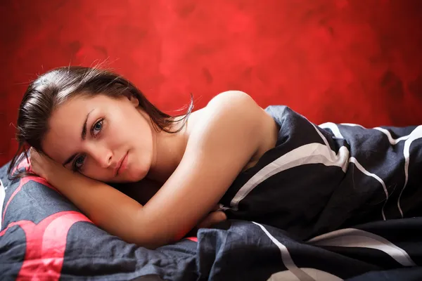 Sexy mladá žena ležela v posteli — Stock fotografie