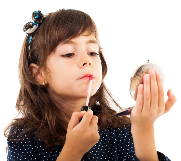 Kleines Mädchen benutzt Lippenstift, während es in den Spiegel schaut — Stockfoto