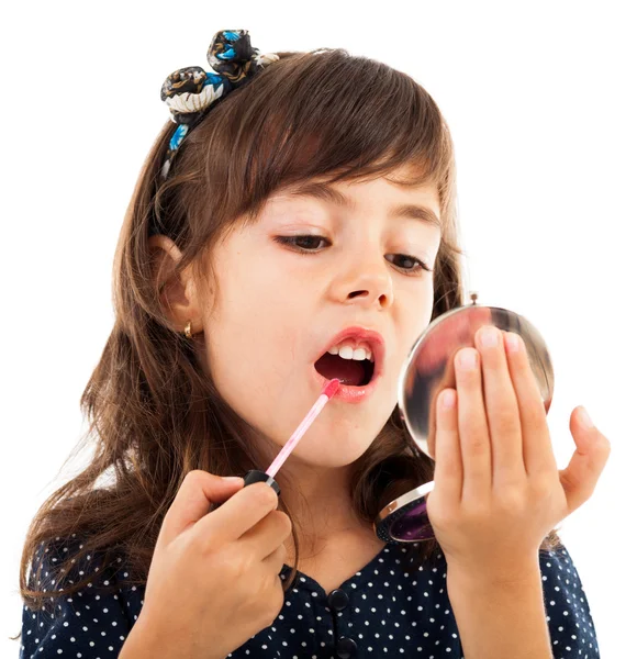 Meisje met behulp van lippenstift terwijl in de spiegel kijken — Stockfoto