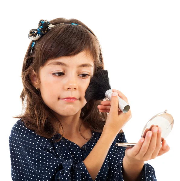 Niña usando polvo facial mientras se mira en el espejo —  Fotos de Stock