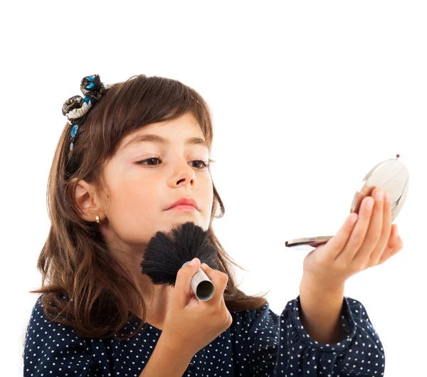 Kleines Mädchen benutzt Gesichtspuder, während es in den Spiegel schaut — Stockfoto