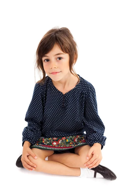 Маленькая девочка сидит со скрещенными ногами — стоковое фото
