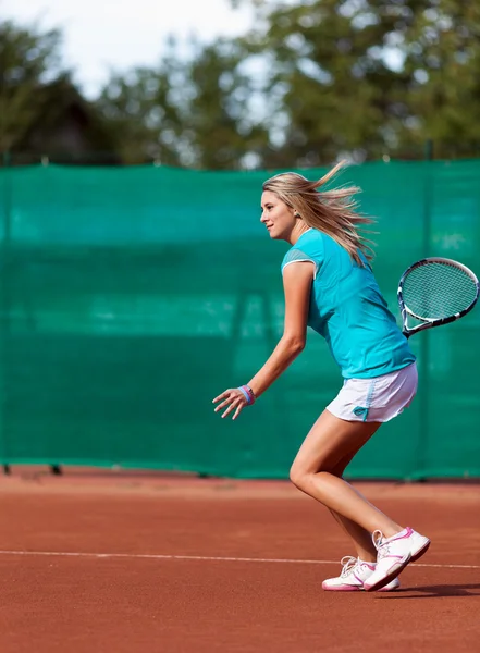 Mujer joven jugando al tenis en un campo de escoria — Foto de Stock