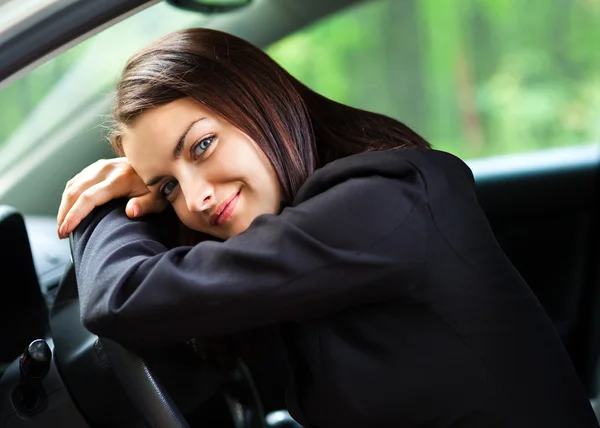 Mladá žena položenou hlavu na volantu — Stock fotografie