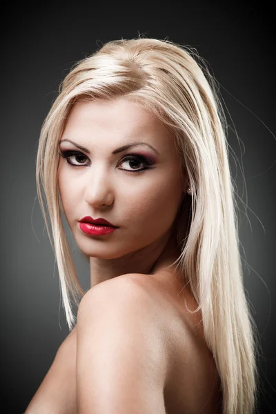 Schöne blonde Frau auf grauem Backgrond — Stockfoto