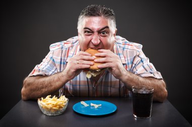 Greedy man eating burger
