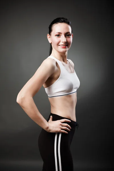 Beautiful sporty woman standing with hands on hips — Stock Photo, Image