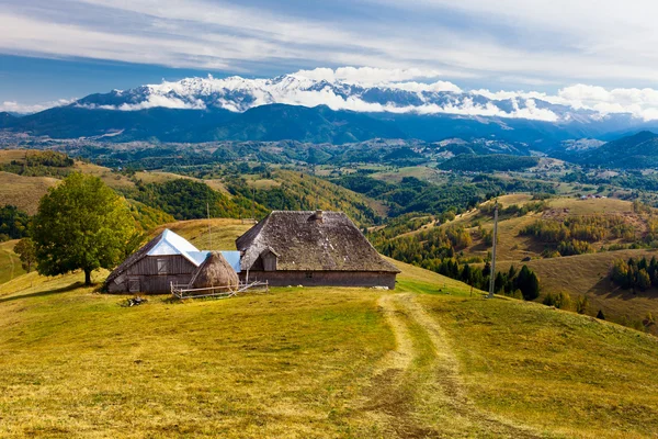 Paysage avec une maison traditionnelle en bois et des montagnes dans le b — Photo