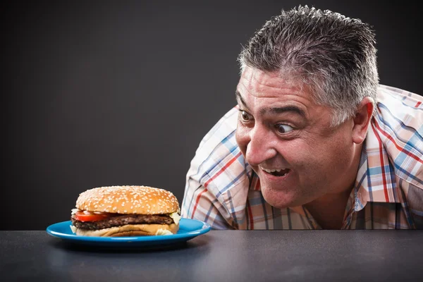 Hombre codicioso mirando hamburguesa —  Fotos de Stock