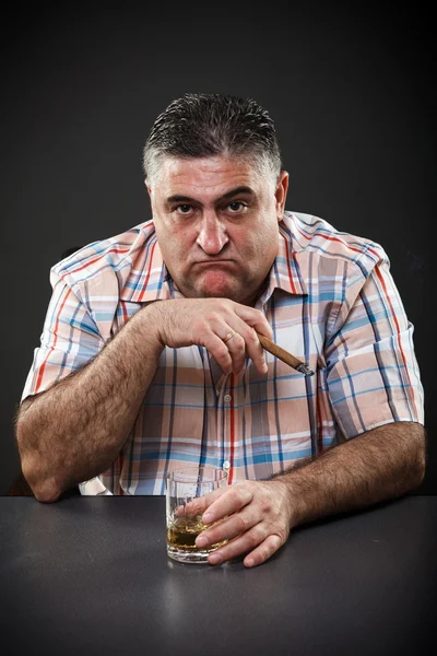 成熟したマフィアの男、テーブルに坐っている間喫煙と飲酒 — ストック写真
