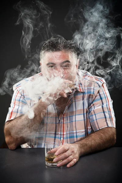 Reifer Mafia-Mann trinkt und raucht, während er am Tisch sitzt — Stockfoto
