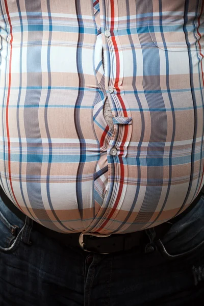 Fechar-se de uma camisa apertada na barriga — Fotografia de Stock