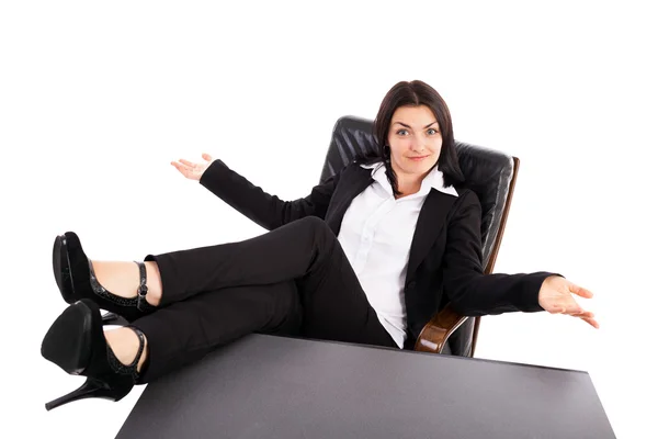 Jonge zakenvrouw zitten in een leunstoel met benen op tafel — Stockfoto