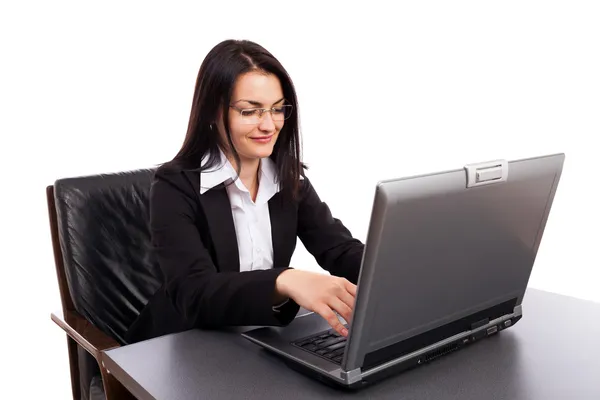 Bir armcha otururken dizüstü bilgisayarda çalışan genç iş kadını — Stok fotoğraf