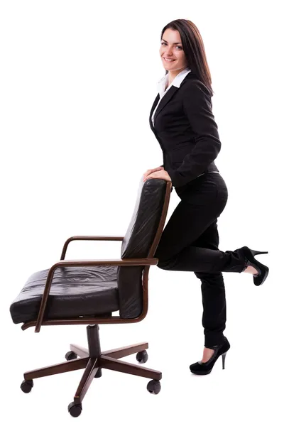 Young businesswoman leaning on an armchair isolated on white bac — Stock Photo, Image