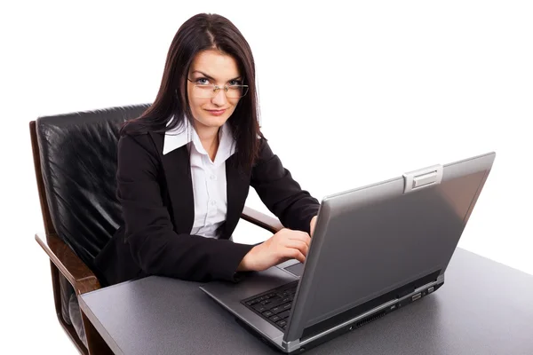 Junge Geschäftsfrau arbeitet am Laptop, während sie im Sessel sitzt Stockbild