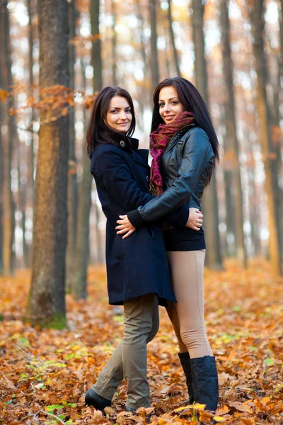 Duas jovens amigas abraçadas na floresta — Fotografia de Stock