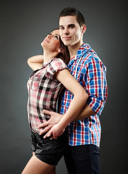 Pareja joven abrazando sobre fondo gris —  Fotos de Stock