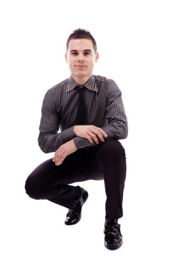 çömelmiş pozisyonda oturan genç adam