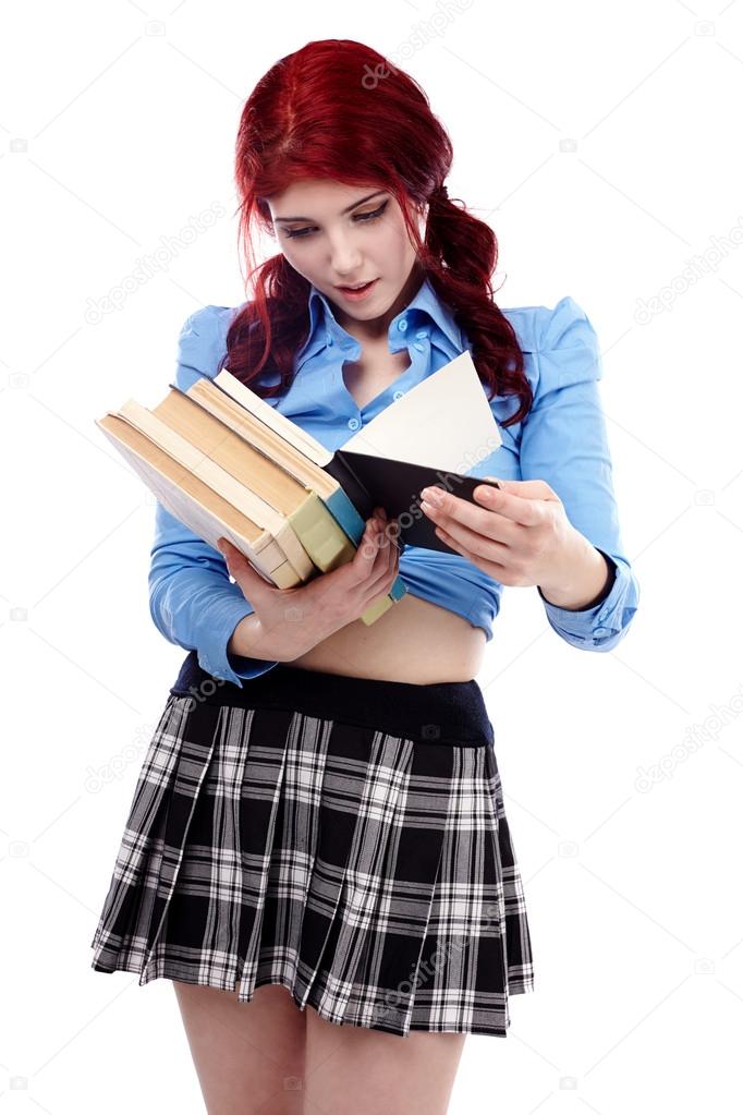 Young schoolgirl browsing through a stack of books