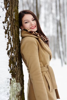 güzel esmer bir ağaç gövdesinde kışın yaslanmış