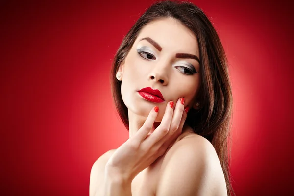 Hermosa morena glamour sobre fondo rojo — Foto de Stock