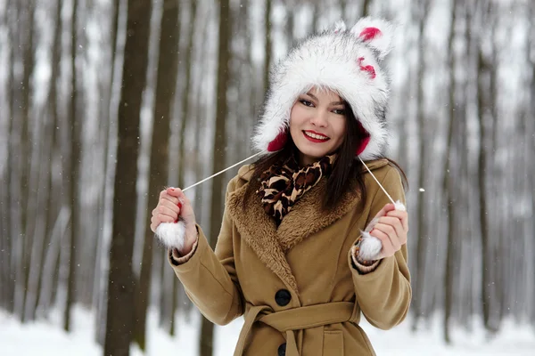 Piękna kobieta w kapeluszu futro w lesie w zimie — Zdjęcie stockowe