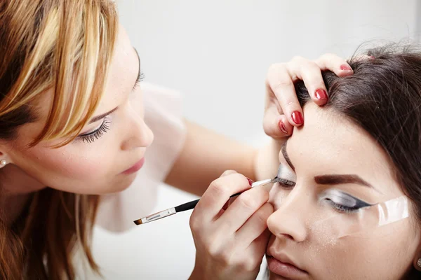 Woman having makeup applied by makeup artist Stock Image