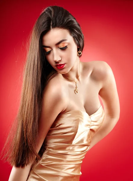 Beautiful woman posing on red background — Stock Photo, Image