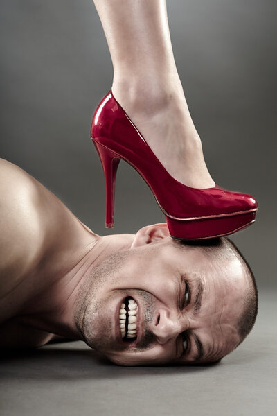 Woman's foot crushing man's head