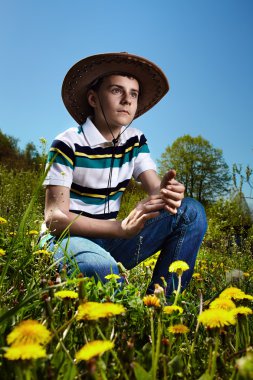 karahindiba alana oturan çocuk