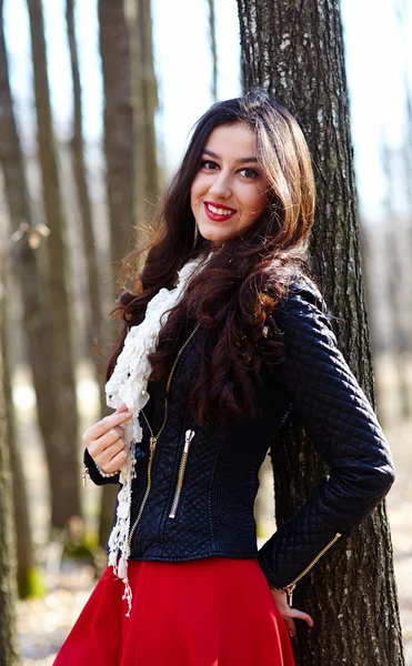 Hermosa mujer apoyada en un tronco de árbol — Foto de Stock