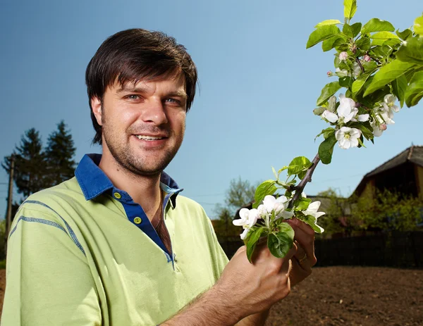 Jonge landbouwer met een appelboom — Stockfoto