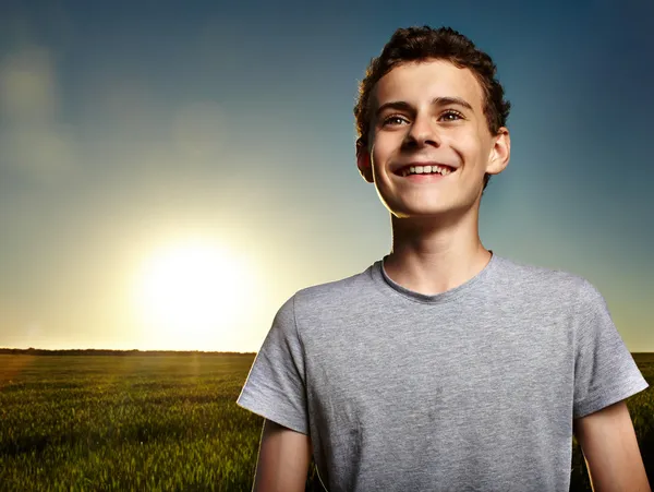 Хлопчик у пшеничному полі на заході сонця — стокове фото