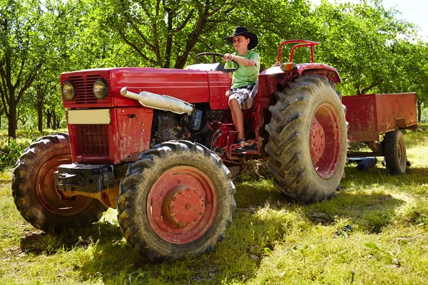 10 代の少年が、トラクターの運転 — ストック写真