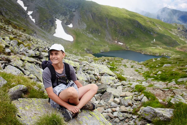 Tonåring med ryggsäck på berg — Stockfoto