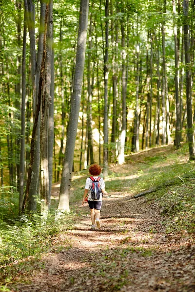 Vrouw met rugzak in het bos — Stockfoto