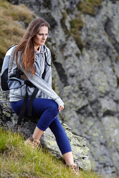 Vrouw wandelaar rusten op een rots — Stockfoto