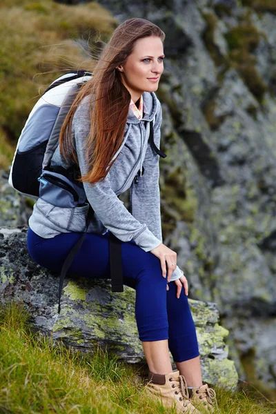 Vrouw wandelaar rusten op een rots — Stockfoto