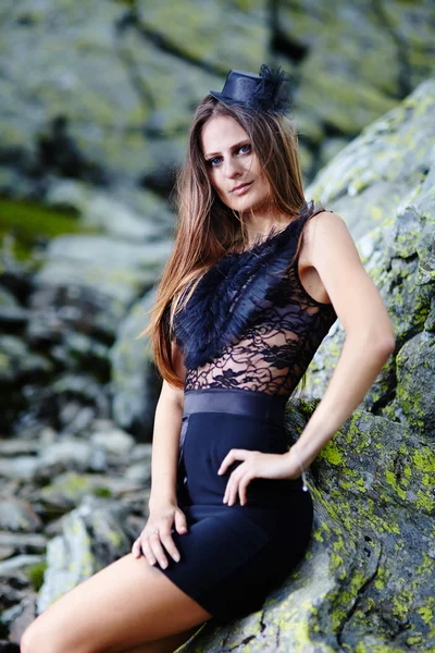 Hermosa dama en vestido apoyado en las rocas de la montaña — Foto de Stock