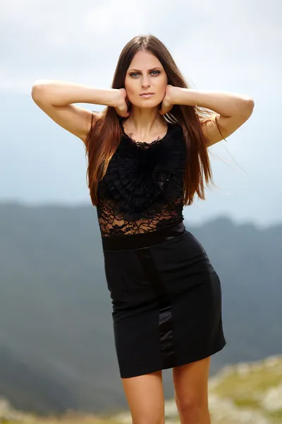 Elegant lady in dress standing on the mountain rocks — Stock Photo, Image