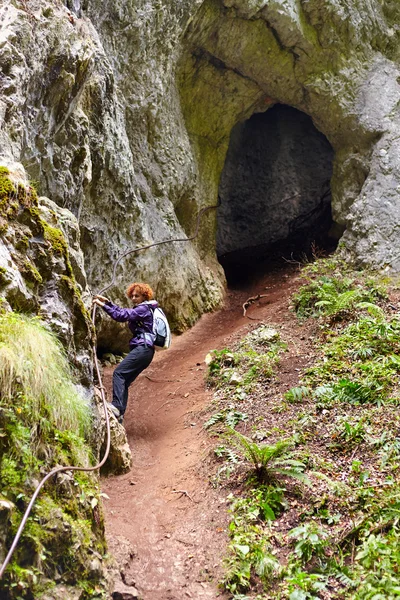 Frau steigt aus Höhle aus — Stockfoto