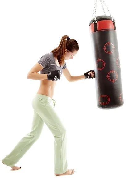 Mujer atlética golpeando el saco de boxeo — Foto de Stock